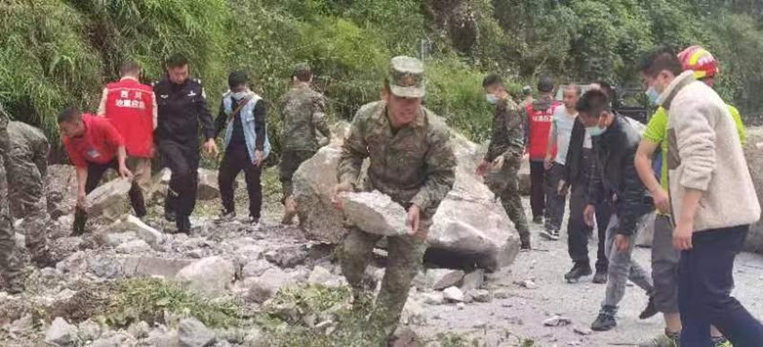 搬開落石清理道路。四川省軍區供圖