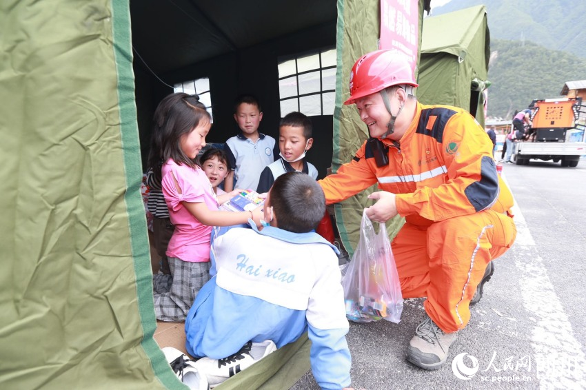 9月6日，國網四川電力（德陽）連心橋共產黨員服務隊隊長魯鵬及隊員們在瀘定縣磨西鎮貢嘎廣場安置點，檢查帳篷中的用電線路，與帳篷中的老人們親切聊天，和小朋友們玩游戲，陪他們度過特殊時光。馬健攝