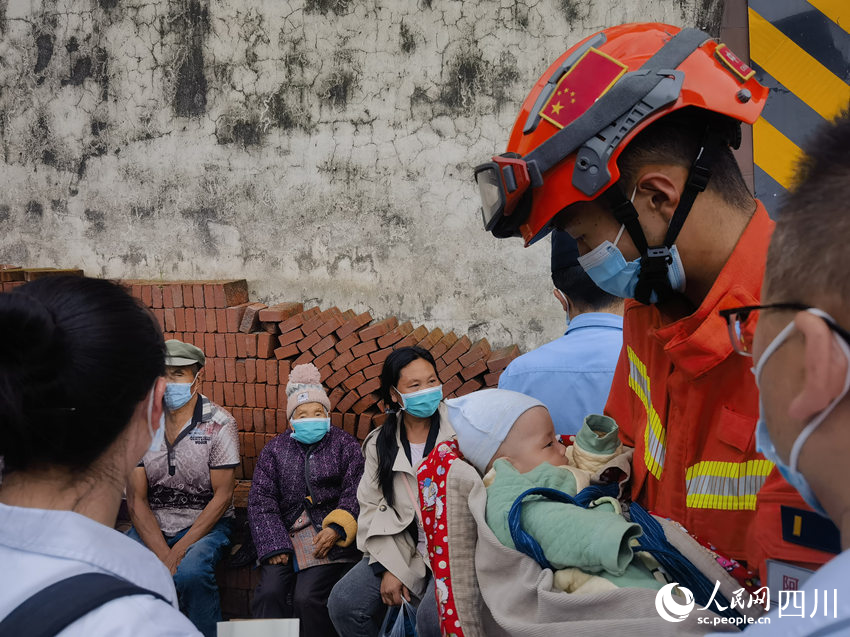 寶寶安靜地在森林消防員懷里。彭科攝