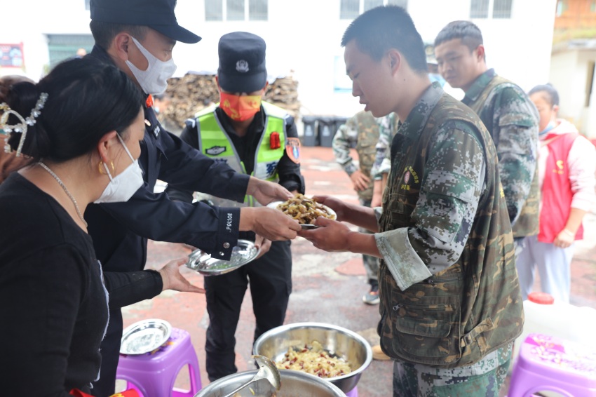 民警為救援戰(zhàn)士盛飯。甘孜公安供圖