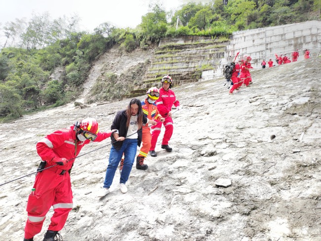 9月6日，在甘孜州瀘定縣磨西鎮，救援人員用繩索從山上轉運傷員。四川省應急管理廳供圖