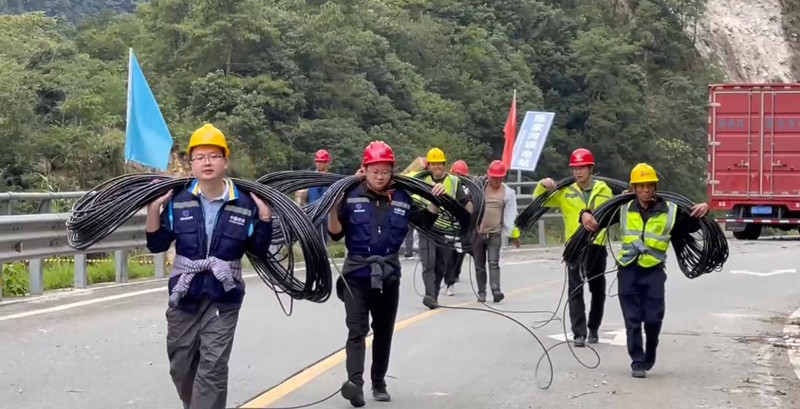 四川移動樂山分公司黨員突擊隊負重徒步前往災區指定地域。四川省國資委供圖