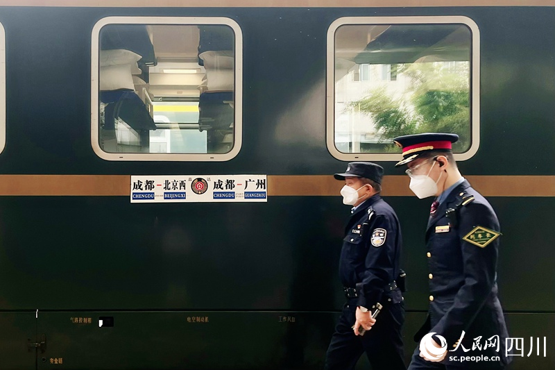 發車前，列車長從列車前經過。人民網 趙祖樂攝