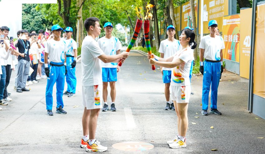 火炬手正在傳遞交接。成都大運(yùn)會執(zhí)委會供圖