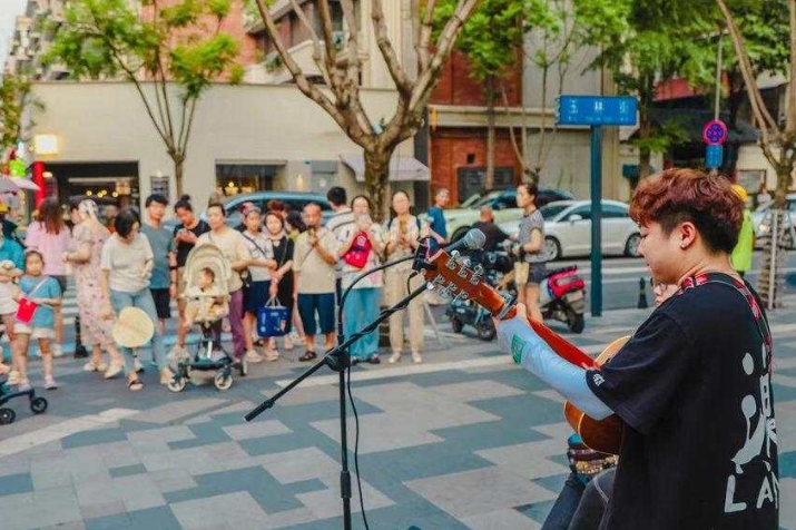 街頭藝人的表演深深吸引路人。成都市武侯區玉林街辦供圖