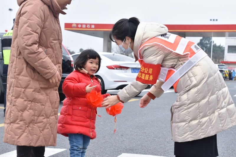 蜀道集團成渝公司成仁高速永興服務區志愿服務者向司乘朋友贈送禮品掛件。蜀道集團供圖