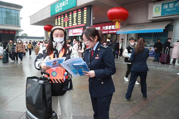 稅務干部在火車站出口向返鄉人員進行稅費優惠政策宣傳。達州市稅務局供圖