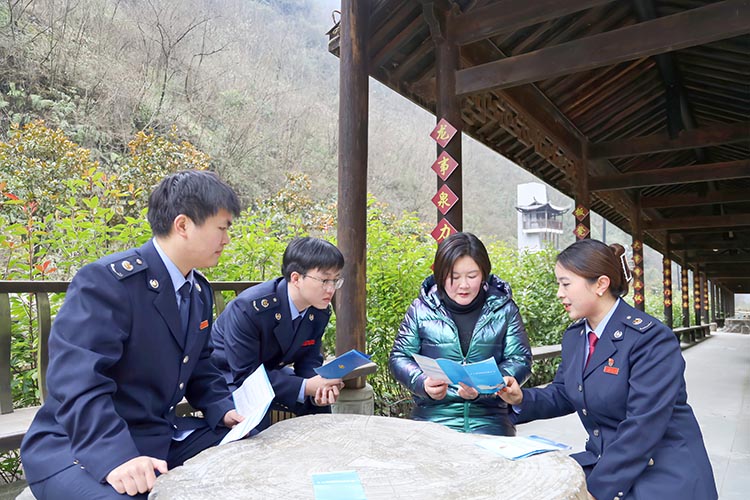 稅務干部向胡曉玲宣傳稅收政策。達州市稅務局供圖