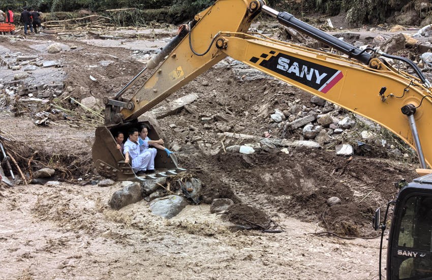 救援人員坐上挖掘機挖斗轉運救治受災村民。雅安市120急救中心供圖