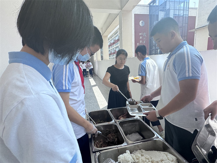 桑玉艷幫學(xué)生們打飯。青羊區(qū)教育局供圖