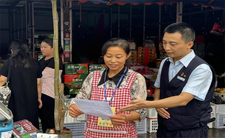 雙流航空港支行人員在成都農產品批發市場為商戶介紹聚合支付服務。建行四川省分行供圖