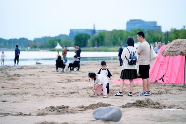 小朋友在興隆湖畔玩海沙。天府新區融媒體中心供圖